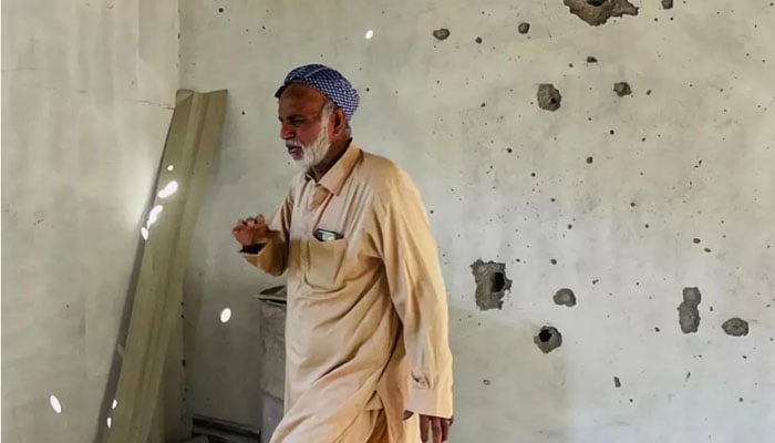 A resident is pictured inside his damaged house in Chakothi — AFP
